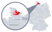 Diese Grafik zeigt eine Karte von Deutschland mit einer detaillierten Ansicht der Region Kiel. Kiel ist in Rot hervorgehoben und liegt im nördlichen Teil Deutschlands. Ein Lupensymbol vergrößert diesen Bereich, um die Lage genauer darzustellen.