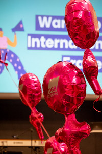 Pinke Luftballons in Form des Zeichens für Frauen mit der Aufschrift DGB Frauen fliegen gefüllt mit Helium in einem Konferenzsaal.